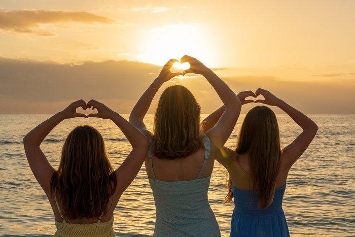 sisters enjoy parents' sunset beach elopement
